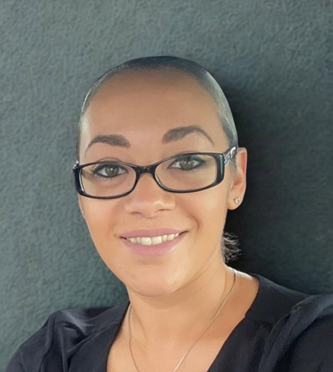 Tia, founder of Mindful Bookkeeping, in a dark top against a grey studio background.